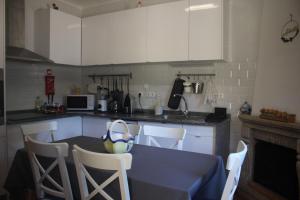a kitchen with a table and chairs and a kitchen with white cabinets at Casa dos Leme in Baião