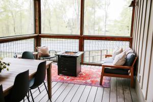 a room with chairs and a table and windows at Azalea & Blackberry Cabins in Jasper