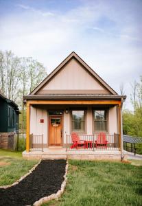 a small house with two red chairs on the porch at Azalea & Blackberry Cabins in Jasper
