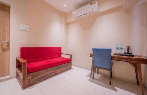 a red bench in a room with a desk and a chair at Indie Stays Studio Kharadi in Pune