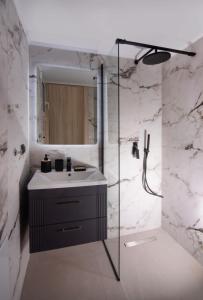 a bathroom with a sink and a glass shower at Joanna Holiday Home in Egina +16 photos