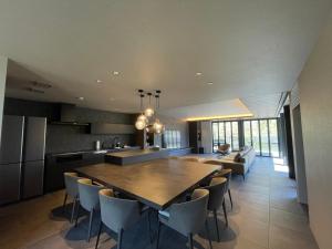 a kitchen and dining room with a wooden table and chairs at Fuji Yamanakako Villa in Yamanakako