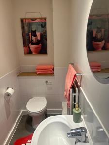 a bathroom with a toilet and a sink and a mirror at Modern 2 bed flat with parking by Bluewater shopping mall in Greenhithe