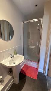 a bathroom with a white sink and a shower at Modern 2 bed flat with parking by Bluewater shopping mall in Greenhithe +11 photos
