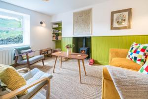 a living room with a couch and a table at 4 Low Rake - Former Miners Cottage in Glenridding