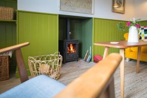 a living room with a fireplace and a table at 4 Low Rake - Former Miners Cottage in Glenridding