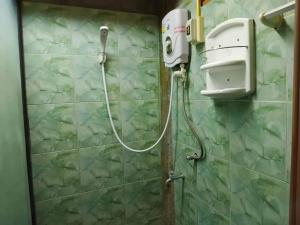 a shower in a bathroom with a green tiled wall at Belvilla Baan Elephant Home in Chiang Mai