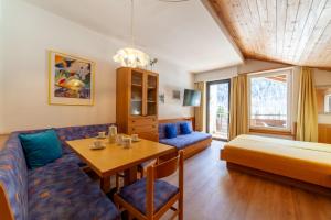 a living room with a couch and a bed and a table at Alpina Residence in Solda