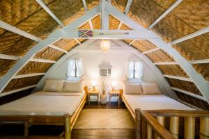 an attic room with two beds and a table at Alaya Panglao in Panglao Island