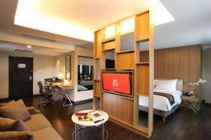 a hotel room with a bed and a tv at Swiss-Belhotel Airport Jakarta in Tangerang