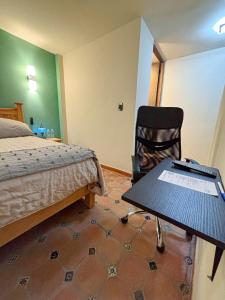 a bedroom with a bed and a table and a chair at La Estancia de Rey David in San Luis Potosí