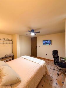 a bedroom with a bed and a ceiling fan at La Estancia de Rey David in San Luis Potosí