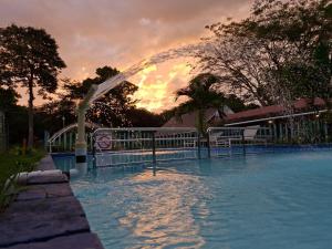 a large swimming pool with a white arch in the water at Hotel Casa Pueblo in Ocú