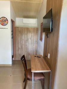 a wooden table and chair in a room with a television at Hotel Casa Pueblo in Ocú