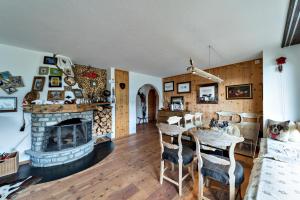 a living room with a fireplace and a table and chairs at Chesa Flurigna - Zuoz in Zuoz