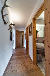 a hallway of a house with wooden floors and a bathroom at Chesa Flurigna - Zuoz in Zuoz +12 photos