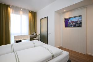 a hotel room with two beds and a desk at Premier Inn München City West in Munich +17 photos