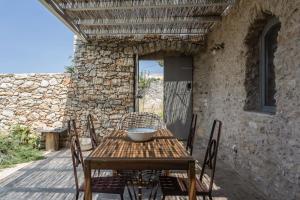 a wooden table and chairs on a patio at Oxalis Villas in Perlengiánika