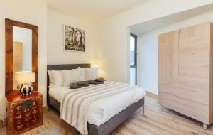 a bedroom with a large bed and a mirror at Rena's Retreat - Luxury Architectural Eco Home with hot tub a short walk from Gurnard in Cowes - Perfect Lux Stay for Sailers Couples and Older Families in Gurnard
