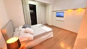 a bedroom with a bed and a television in it at Apto Dangui Amplo in Santa Maria +4 photos