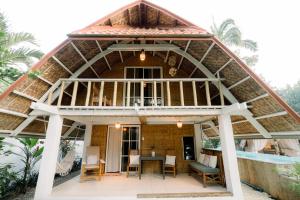 a house with a round roof with a table and chairs at Alaya Panglao in Panglao Island