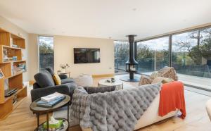 a living room with a couch and a fireplace at Rena's Retreat - Luxury Architectural Eco Home with hot tub a short walk from Gurnard in Cowes - Perfect Lux Stay for Sailers Couples and Older Families in Gurnard