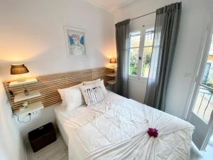 a bedroom with a white bed and a window at Apollo House in Lefkada