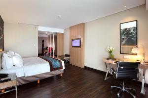 a hotel room with a bed and a desk with a computer at Swiss-Belhotel Airport Jakarta in Tangerang