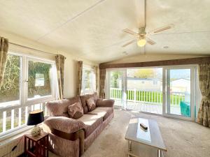 a living room with a couch and a ceiling fan at Oaklands Holiday Park in Saint Osyth
