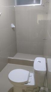 a white bathroom with a toilet and a shower at Habitaciones Chincha in Sunampe