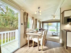 a kitchen and dining room with a table and chairs at Oaklands Holiday Park in Saint Osyth
