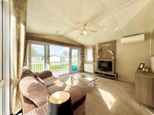 a living room with a couch and a table at Oaklands Holiday Park in Saint Osyth