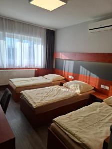 a hotel room with three beds and a window at Ambrozja in Strzelin
