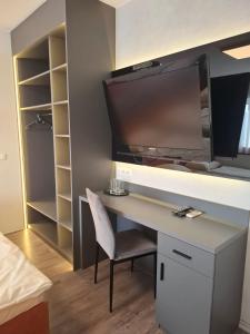 a desk with a tv and a chair in a room at Ambrozja in Strzelin