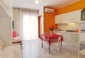 a kitchen with a red table with a red table cloth at Appartamenti Foyer in Bibione