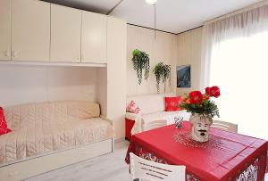 a bedroom with a bed and a table with flowers on it at Appartamenti Foyer in Bibione