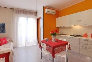 a kitchen with a table with a red table cloth at Appartamenti Foyer in Bibione