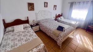 a bedroom with two beds and a window at Casa Rural Cortijo Cerro Limon in Málaga +28 photos