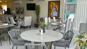 a dining room with white tables and chairs at Onyx luxury rd in La Romana