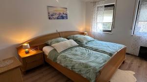 a bedroom with a bed with a wooden head board at Ferienwohnung Wirtz in Olzheim
