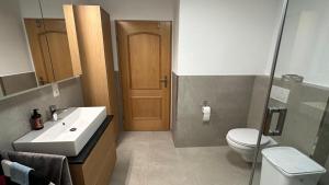 a bathroom with a sink and a toilet and a door at Ferienwohnung Wirtz in Olzheim +24 photos