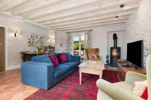a living room with a blue couch and a fireplace at 2 Bed in St. Brides oc-s30491 in Saint Brides