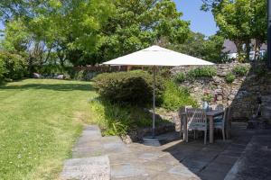 a table and chairs under an umbrella in a yard at 2 Bed in St. Brides oc-s30491 in Saint Brides