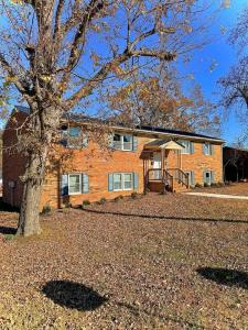 a brick house with a tree in front of it at Crewe Corner Apartment C in Crewe