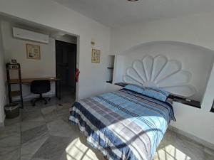 a bedroom with a large bed in a room with a desk at Casa Secretos del Sol in Acapulco +1 photo