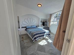 a bedroom with a bed and a large window at Casa Secretos del Sol in Acapulco