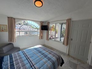 a bedroom with a bed and a large window at Casa Secretos del Sol in Acapulco