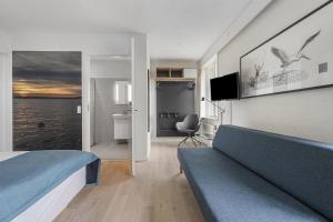 ein Hotelzimmer mit Bett und Fernseher in der Unterkunft Hotel Fuglsocentret, BW Signature Collection in Knebel