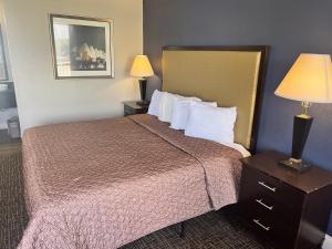 a hotel room with a bed and two lamps at UNIVERSITY INN Winston in Winston-Salem +8 photos