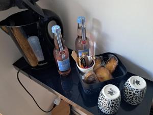 a counter with two bottles and a container of food at Chambres d'hôtes chez Peggy et Eric chambre indus in Équevillon